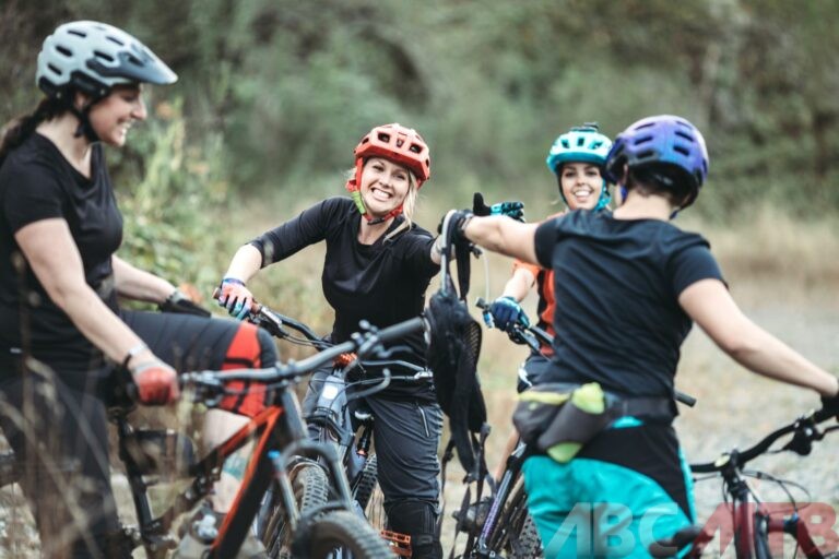 Ragazze in bicicletta che sorridono e conversano tra di loro