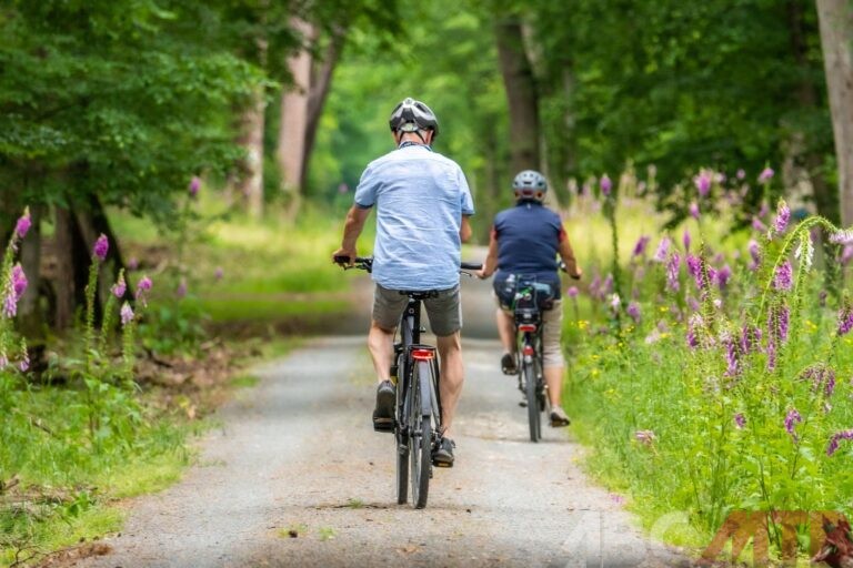 Uomo e donna che pedalano su una mtb in mezzo alla natura